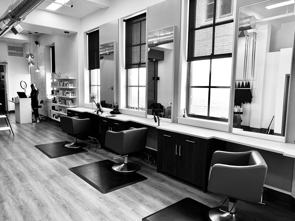 Illuminated vanity mirror stations and styling chairs